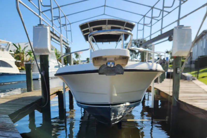 Slide: The Image of 2004 Pursuit 2470 Center Console boat docked in marina, front view. - 24