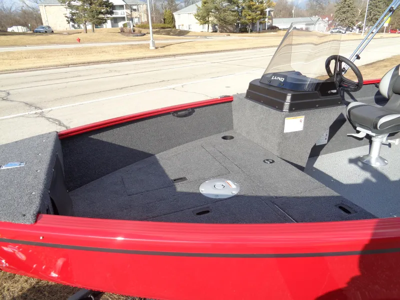 Slide: The Image of 2025 Lund 1650 Rebel XL SS boat, red exterior, spacious interior, parked outdoors. - 11