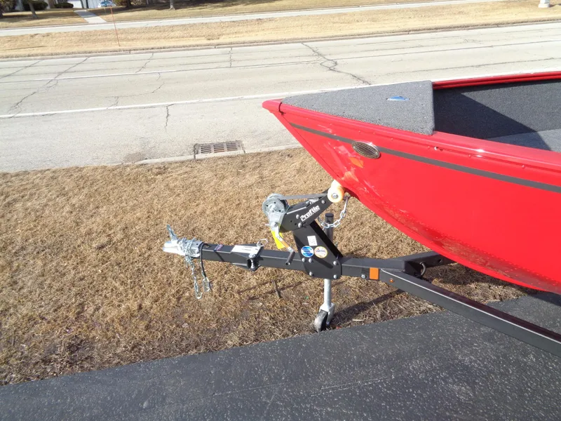 Slide: The Image of 2025 Lund 1650 Rebel XL SS boat on trailer, parked on roadside. - 12