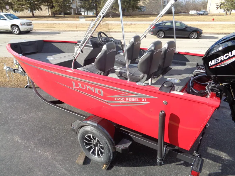 Slide: The Image of 2025 Lund 1650 Rebel XL SS boat, red exterior, on trailer, with Mercury outboard motor. - 15