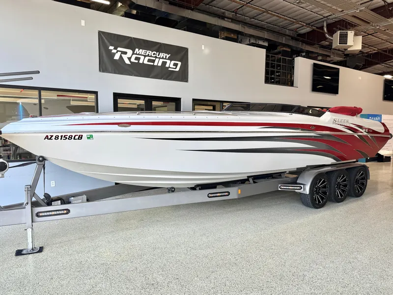Slide: The Image of 2006 Sleekcraft Heritage boat on trailer in showroom, featuring sleek design and vibrant graphics. - 2