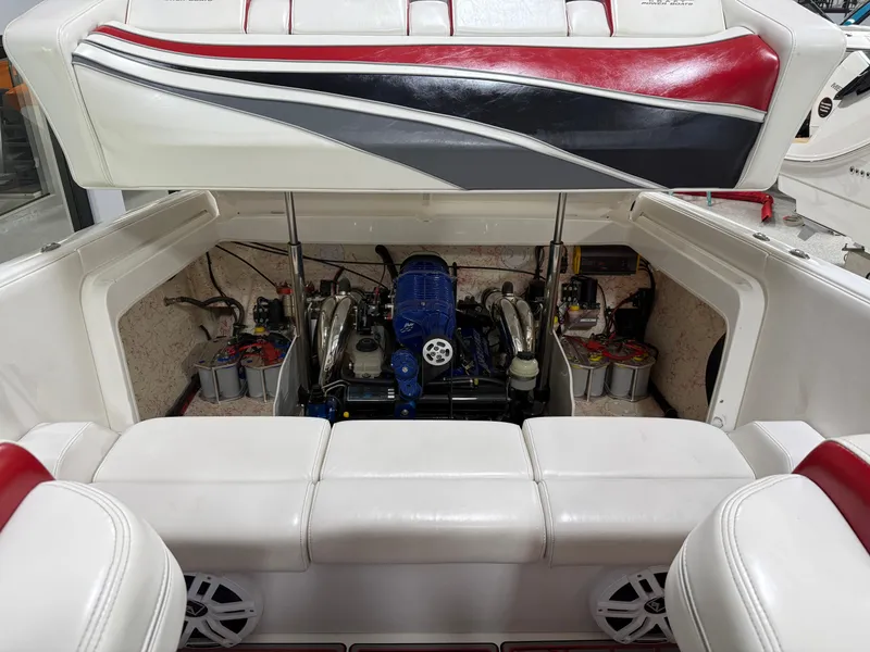Slide: The Image of 2006 Sleekcraft Heritage boat engine compartment with open hatch, showcasing engine and seating. - 21