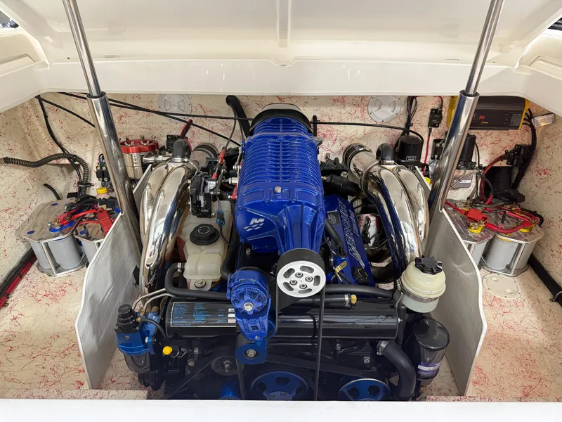 Slide: The Image of Engine compartment of a 2006 Sleekcraft Heritage boat, featuring a powerful blue engine. - 22