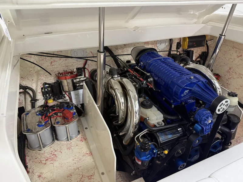 Slide: The Image of Engine compartment of a 2006 Sleekcraft Heritage boat, featuring a powerful blue engine. - 23