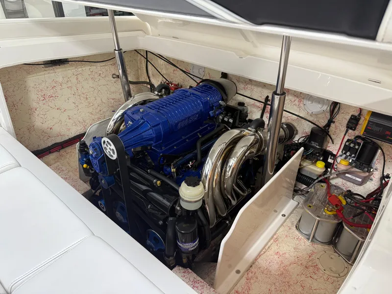 Slide: The Image of Engine compartment of a 2006 Sleekcraft Heritage boat, featuring a powerful blue engine. - 24