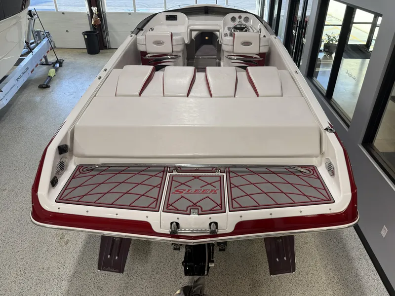 Slide: The Image of 2006 Sleekcraft Heritage boat with red and white interior, viewed from the rear in a showroom. - 26