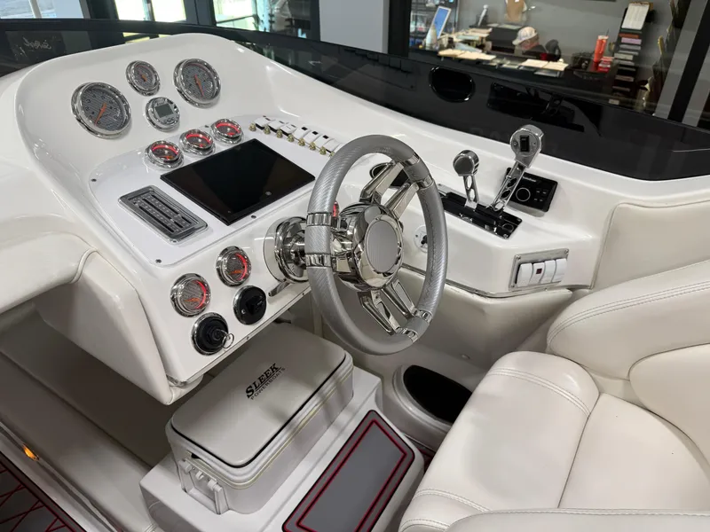 Slide: The Image of 2006 Sleekcraft Heritage boat dashboard with gauges, steering wheel, and controls in a white interior. - 30