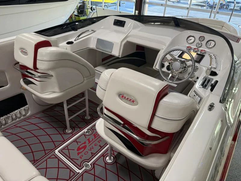 Slide: The Image of 2006 Sleekcraft Heritage boat interior with white and red seating, modern dashboard, and steering wheel. - 35
