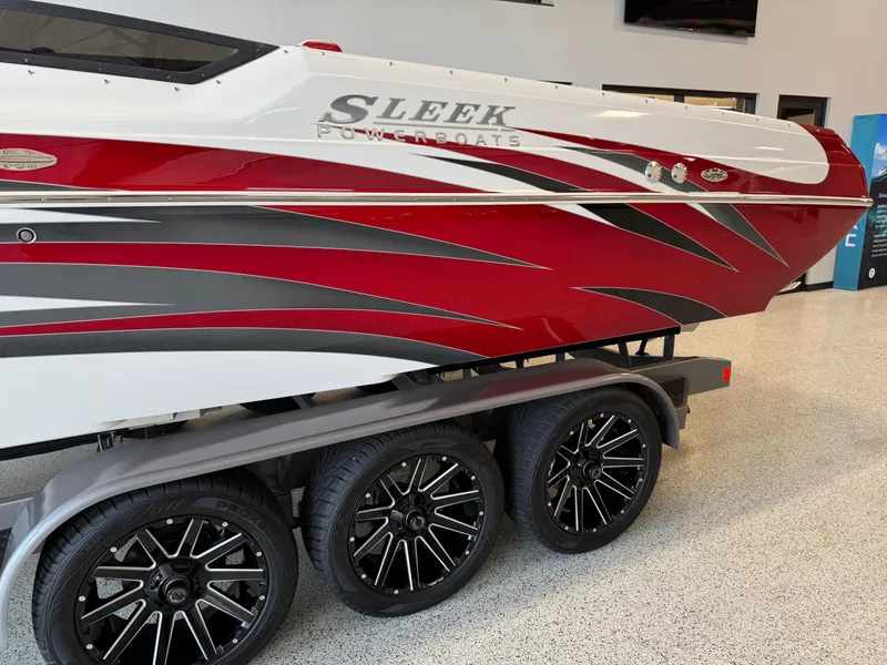 Slide: The Image of 2006 Sleekcraft Heritage boat with red and white design on a triple-axle trailer. - 4