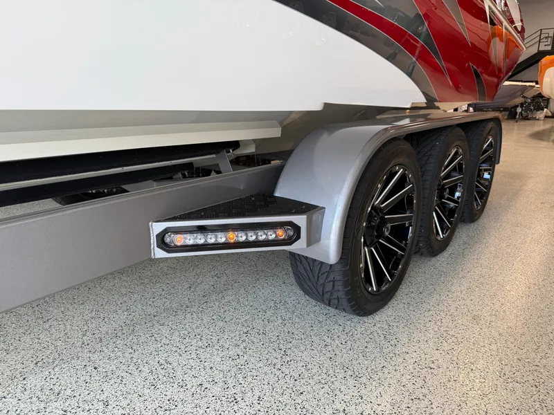 Slide: The Image of 2006 Sleekcraft Heritage boat trailer with black wheels and LED lights in a showroom. - 46