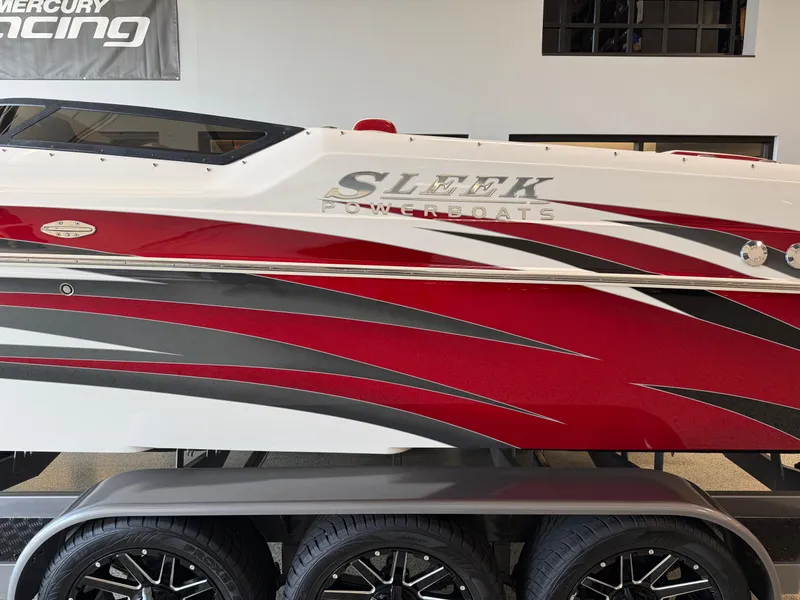 Slide: The Image of 2006 Sleekcraft Heritage powerboat with red, white, and gray design on a trailer. - 5