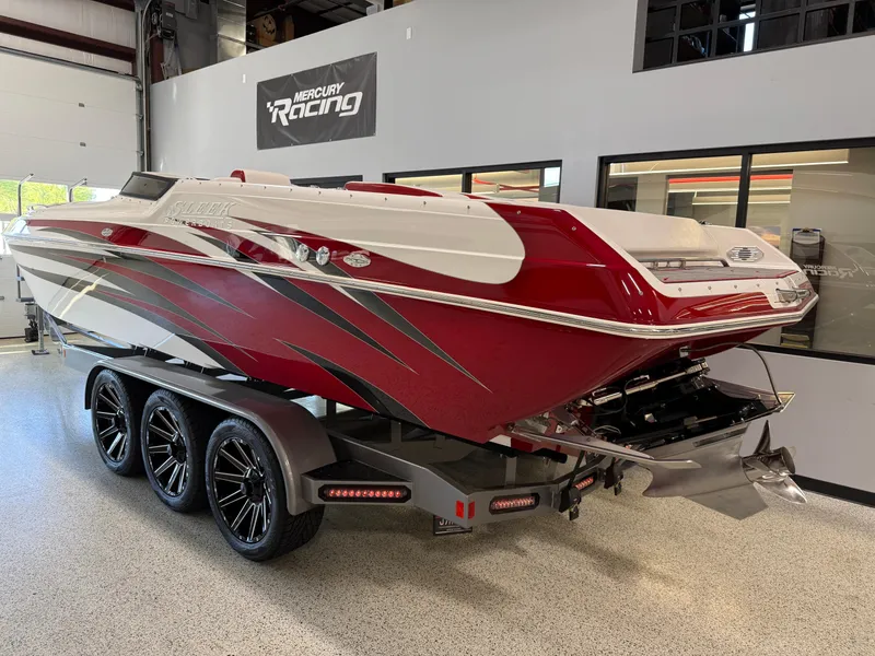 Slide: The Image of 2006 Sleekcraft Heritage boat with red and white design on a trailer in a showroom. - 6