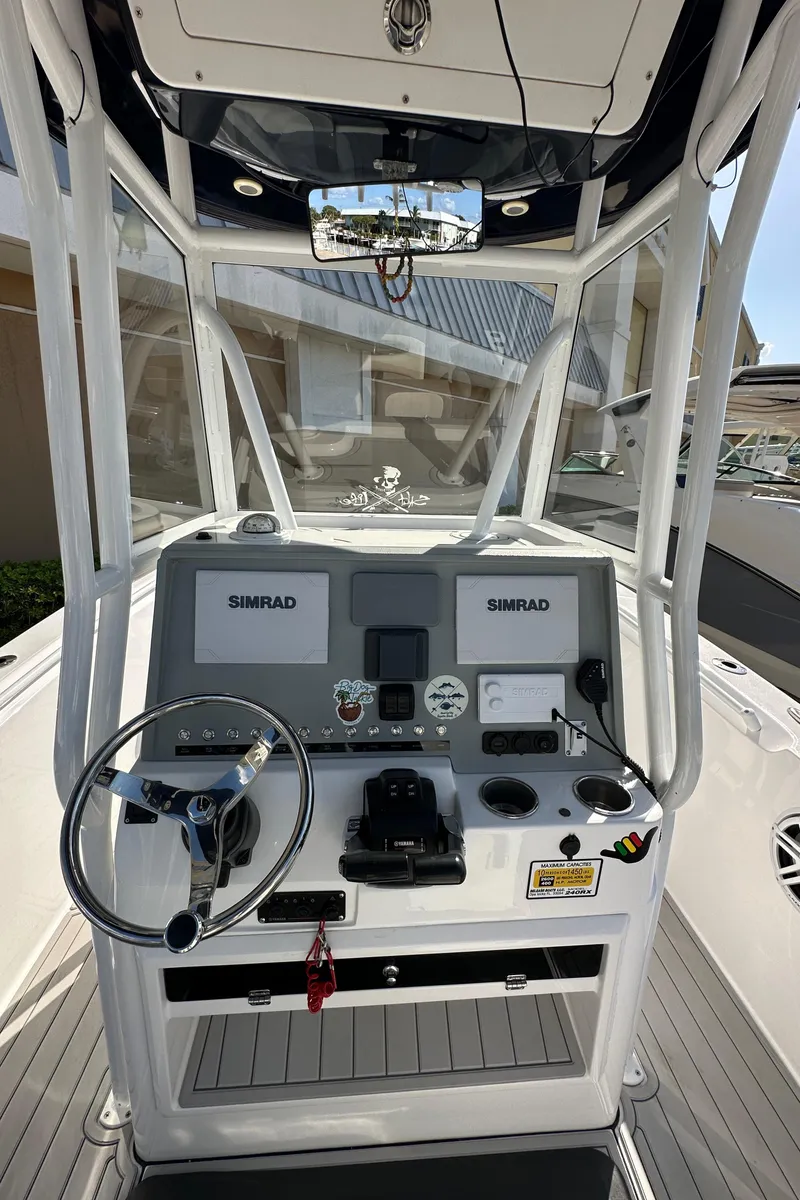 Slide: The Image of 2021 Release 240 RX boat console with dual Simrad displays and steering wheel. - 17