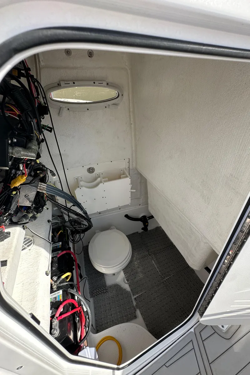 Slide: The Image of Interior of 2021 Release 240 RX boat with compact marine toilet and wiring. - 22