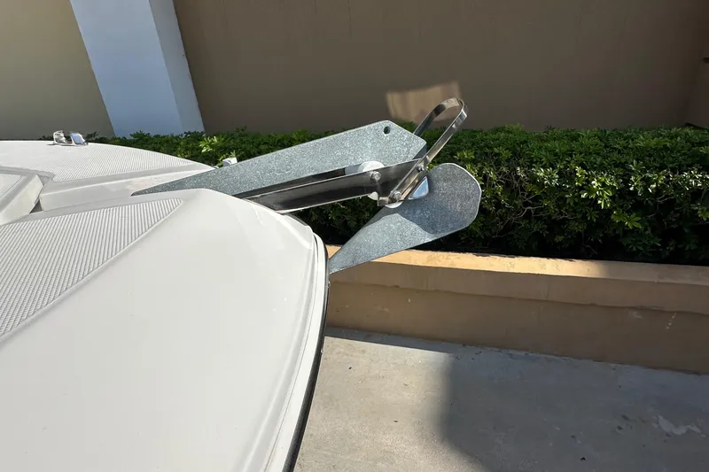 Slide: The Image of Bow of 2021 Release 240 RX boat with anchor, docked near greenery. - 35