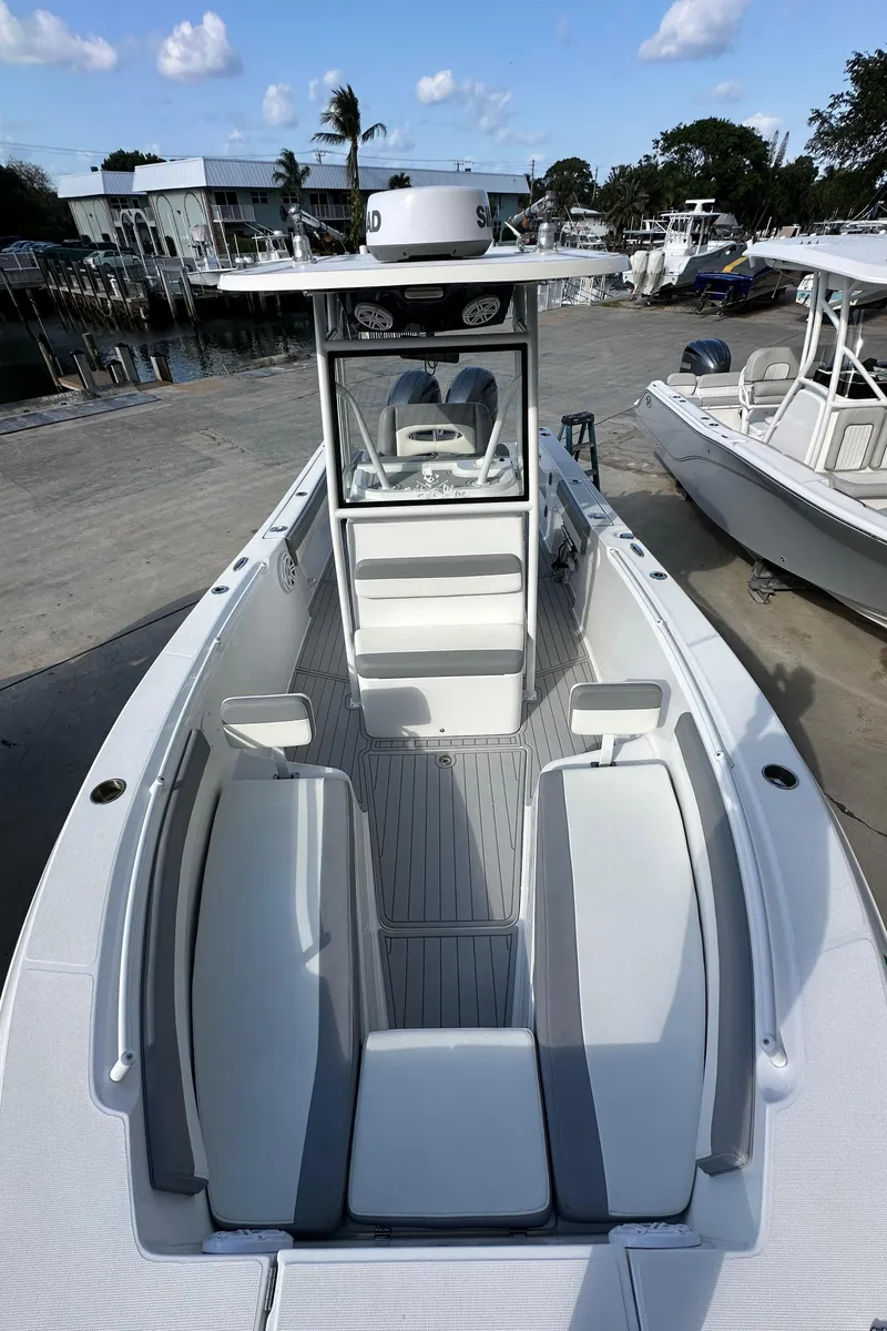 Slide: The Image of 2021 Release 240 RX boat with sleek design, docked at marina under blue sky. - 36