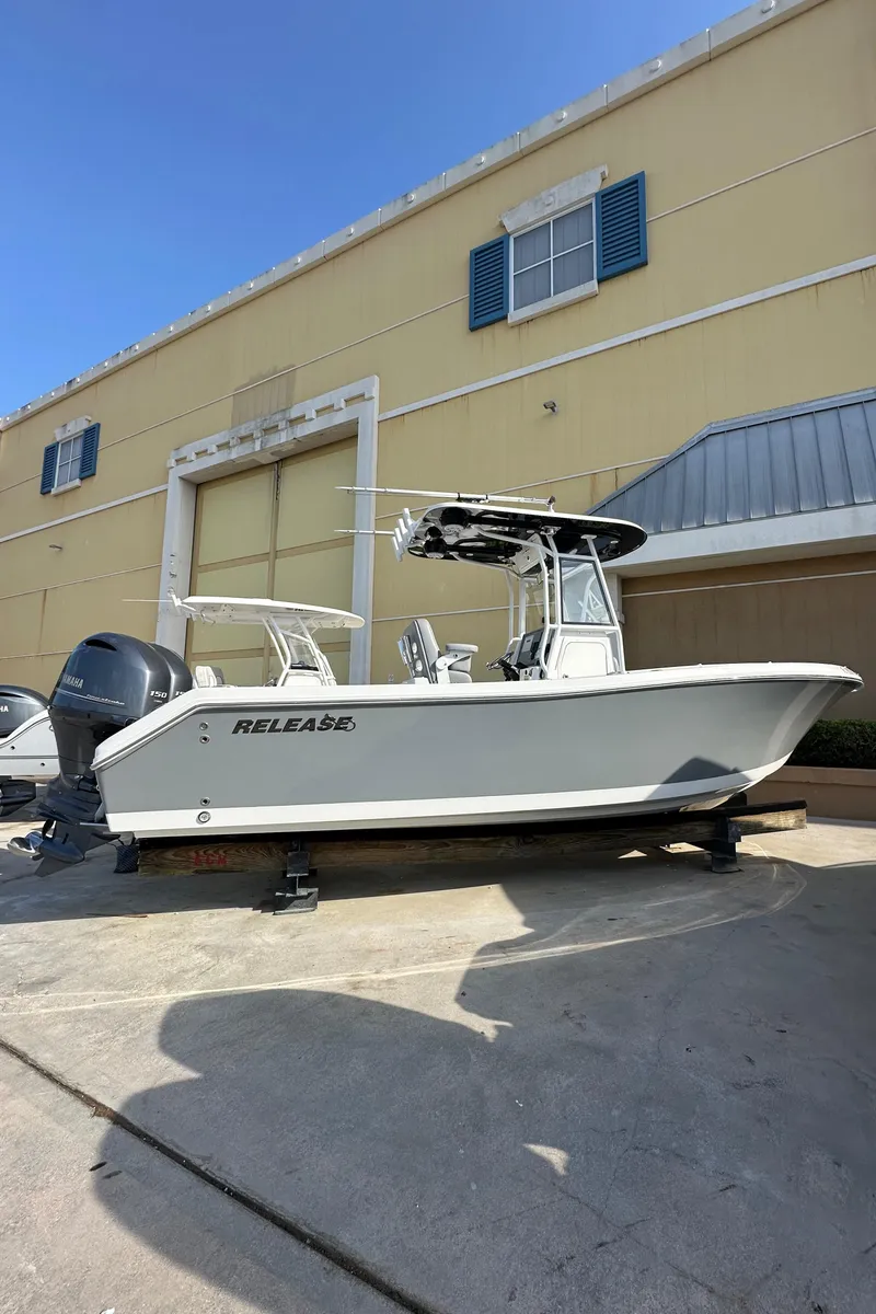 Slide: The Image of 2021 Release 240 RX boat on trailer, parked outside a yellow building. - 4