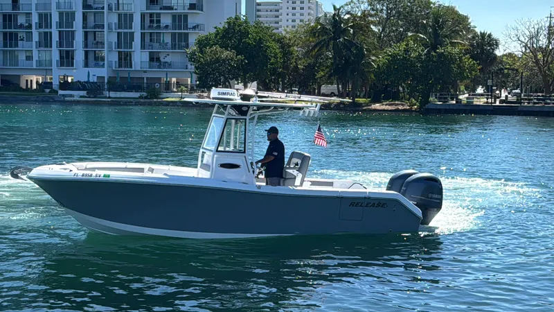 Slide: The Image of 2021 Release 240 RX boat cruising on a sunny waterfront with buildings and trees in the background. - 41