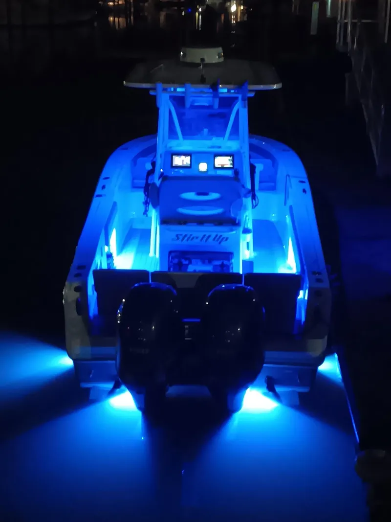 Slide: The Image of 2021 Release 240 RX boat illuminated with vibrant blue LED lights at night. - 43