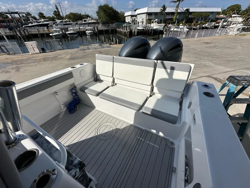 Slide: The Image of 2021 Release 240 RX boat with seating, docked at marina under clear sky. - 6