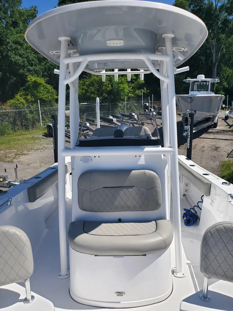Slide: The Image of 2022 Sportsman Open 212 Center Console boat with seating and T-top in a marina setting. - 5
