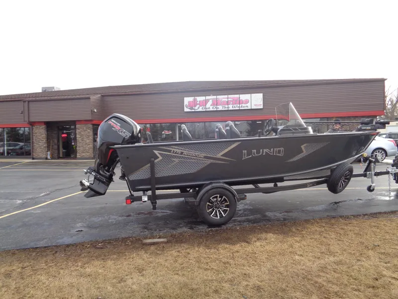 The Image of 2025 Lund 1775 Adventure SS boat on trailer outside a building. - 0