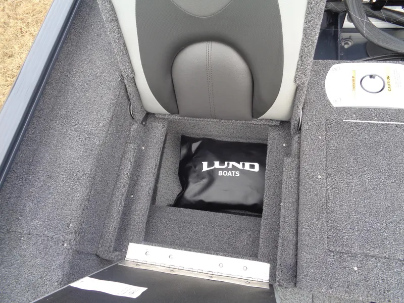 Slide: The Image of 2025 Lund 1775 Adventure SS boat storage compartment with branded bag. - 2