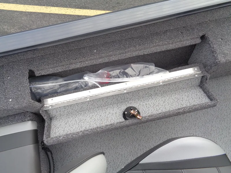 Slide: The Image of 2025 Lund 1775 Adventure SS boat interior storage compartment with gray carpeting. - 20