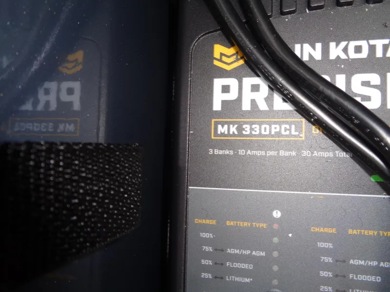 Slide: The Image of Battery charger panel with cables, featuring MK 330PCL model, in a 2025 Lund 1775 Adventure SS. - 28