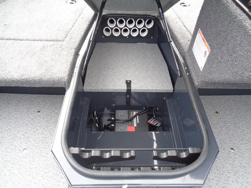 Slide: The Image of 2025 Lund 1775 Adventure SS boat storage compartment with organized rod holders and battery setup. - 29