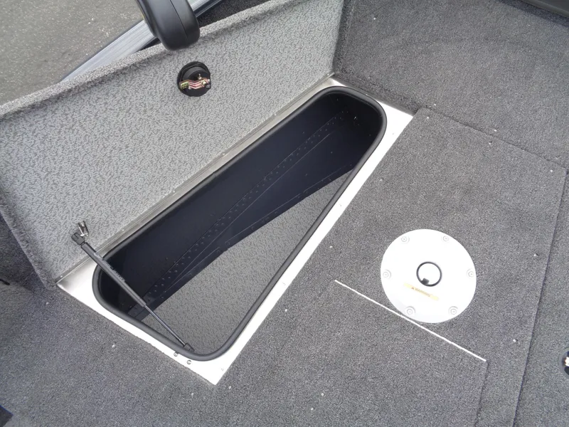 Slide: The Image of 2025 Lund 1775 Adventure SS boat storage compartment with gray carpeted interior. - 31