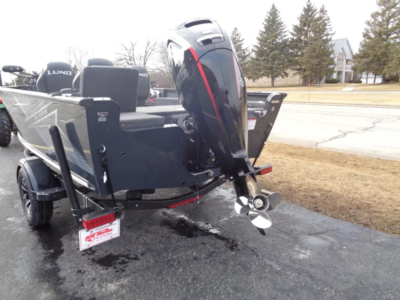 Slide: The Image of 2025 Lund 1775 Adventure SS boat with powerful outboard motor, parked on a driveway. - 6
