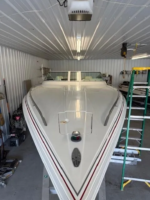 Slide: The Image of 2000 Fountain 27 Fever boat in a garage, white with red accents, stored indoors. - 15