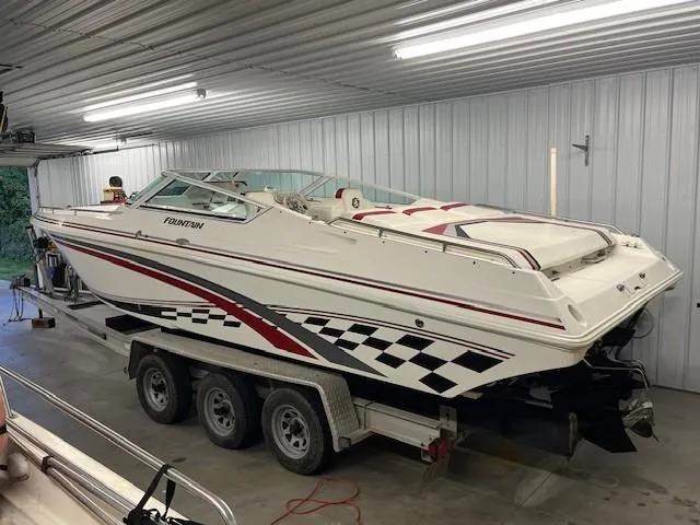 Slide: The Image of 2000 Fountain 27 Fever speedboat on trailer in garage, white with red and black accents. - 2