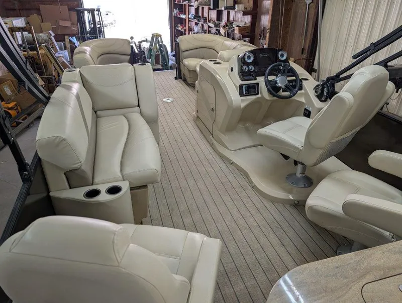 Slide: The Image of 2018 Sylvan Mirage Cruise 8524 Entertainer boat interior with beige seating and steering console. - 14