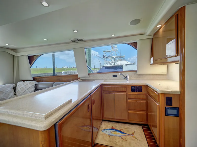 Slide: The Image of Luxurious interior of a 2001 Viking Convertible yacht with modern kitchen and scenic window views. - 10