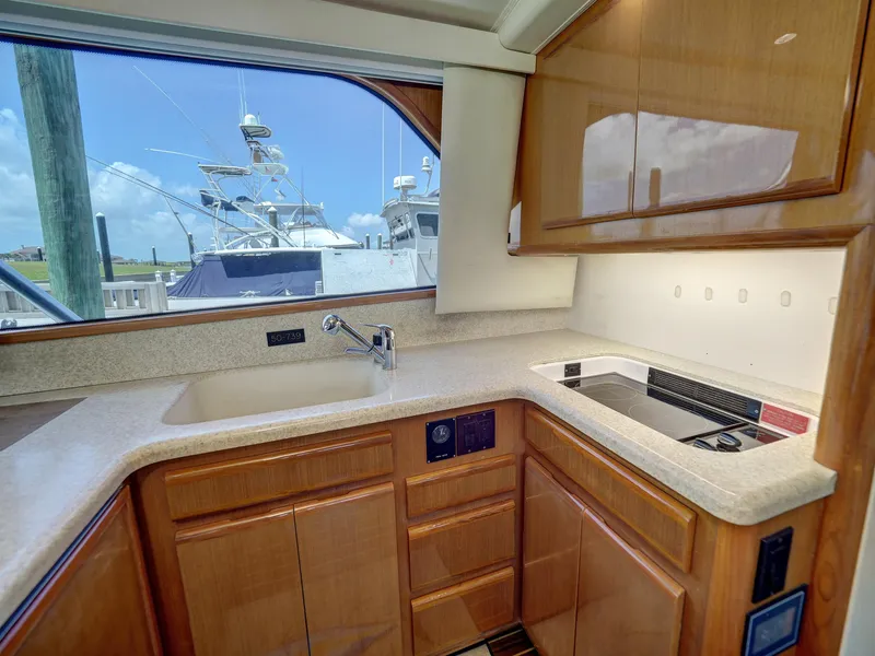 Slide: The Image of 2001 Viking Convertible yacht kitchen with wooden cabinets and countertop, featuring a sink and stove. - 12