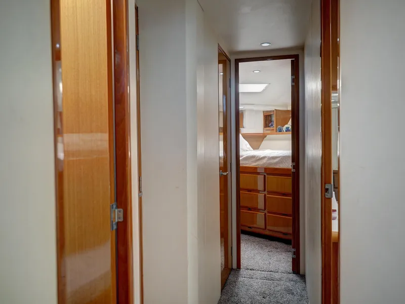 Slide: The Image of Hallway inside 2001 Viking Convertible yacht, featuring wooden doors and carpeted flooring. - 13