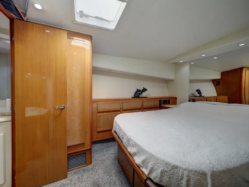 Slide: The Image of Luxurious cabin interior of a 2001 Viking Convertible yacht with cozy bed and wooden accents. - 15