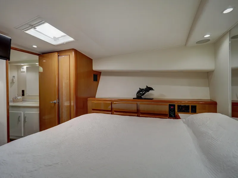 Slide: The Image of Luxurious bedroom interior of a 2001 Viking Convertible yacht with modern amenities. - 16