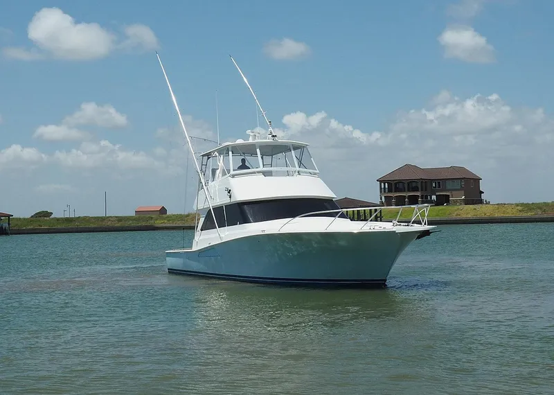 Slide: The Image of 2001 Viking Convertible yacht on calm water with blue sky and clouds. - 2