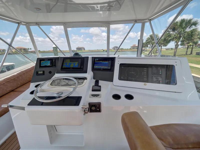 Slide: The Image of 2001 Viking Convertible yacht helm with modern navigation equipment and scenic waterfront view. - 25