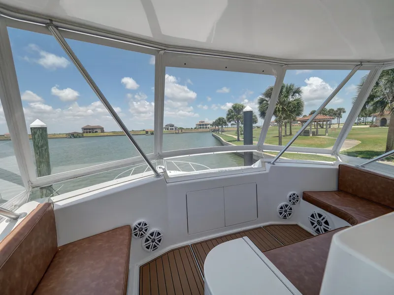Slide: The Image of 2001 Viking Convertible boat interior with waterfront view, featuring comfortable seating and clear windows. - 26