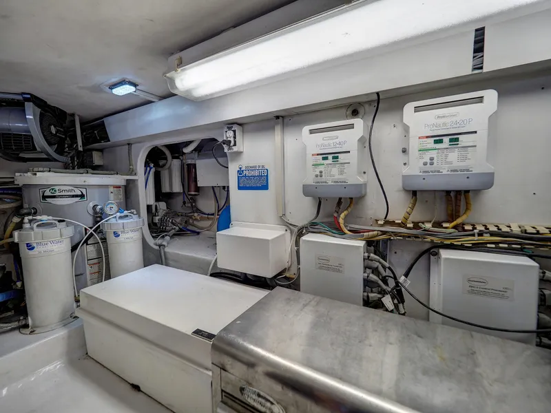 Slide: The Image of Engine room of a 2001 Viking Convertible yacht, featuring control panels and equipment. - 37