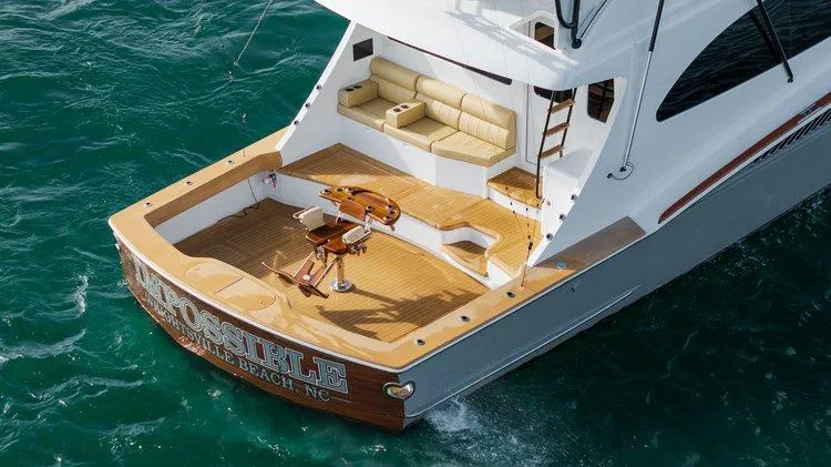 Slide: The Image of 2024 Matthews 62 Sport Fish yacht with spacious deck and seating on the ocean. - 1