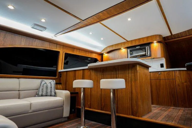 Slide: The Image of Luxurious interior of 2024 Matthews 62 Sport Fish yacht with modern kitchen and seating area. - 10