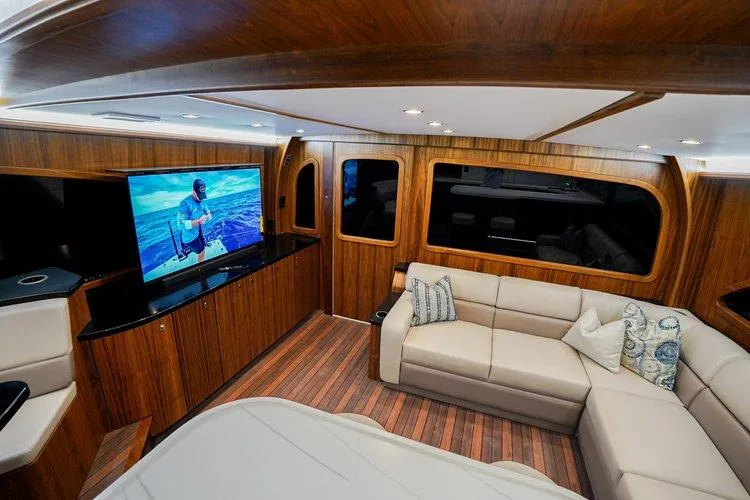 Slide: The Image of Luxurious interior of 2024 Matthews 62 Sport Fish yacht with wood paneling and plush seating. - 13