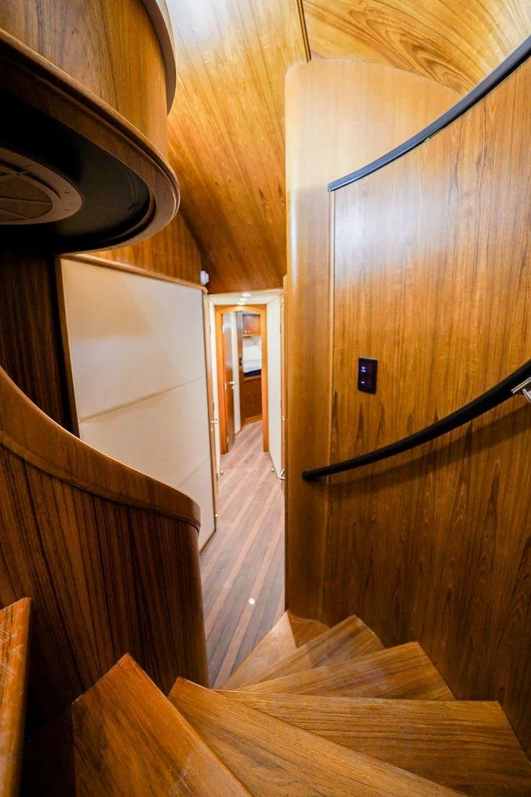 Slide: The Image of Interior of 2024 Matthews 62 Sport Fish yacht with elegant wooden staircase and hallway. - 14