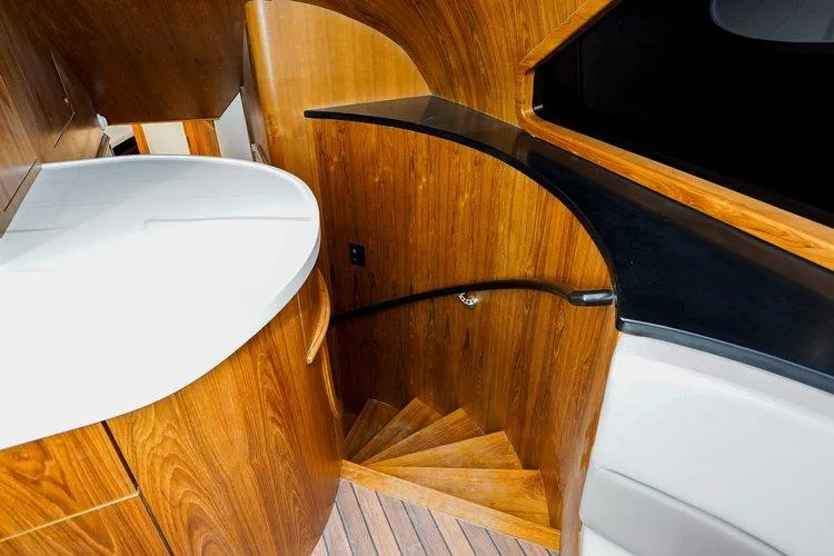 Slide: The Image of 2024 Matthews 62 Sport Fish interior with wooden staircase and modern design. - 15