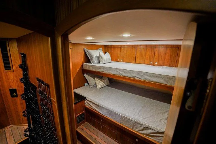Slide: The Image of Bunk beds in the 2024 Matthews 62 Sport Fish yacht cabin, featuring wooden interior. - 17